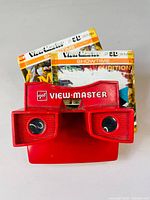 Red gaf View-Master viewer with Muppets reels and damaged sleeves behind