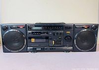 Front view of Panasonic RX-DS650 showing dual cassette decks, radio tuner display, XBS logos, knobs and buttons.