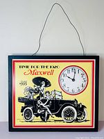 Full front view of the vintage metal hanging clock and sign featuring a 1920 Maxwell automobile and embedded clock.