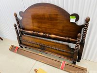 Full view of antique walnut bed headboard, footboard with pineapple topped posts and included side rails wrapped at the base.