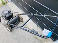 Side angle showing entire Craftsmen gas lawn mower with Briggs and Stratton engine and rear handle in folded position.