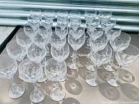 Top view of cut crystal stemware showing multiple wine and cocktail glasses arranged in rows.