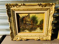 Frontal view of the framed oil painting showing the canal scene and signature.