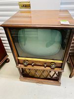 Front view of the vintage Electrohome black and white television in walnut cabinet showing screen, control knobs, and speaker grill.