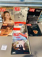 Seven vintage LIFE magazines arranged on a surface, showing colorful photographic covers including an Apollo 12 moon landing and nature.
