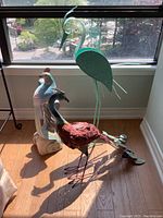 Three bird sculptures together by window, showing overall lot
