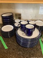 Stacks of large cobalt blue rim dinner plates, white centers