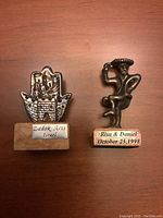 Front view of two Judaica silver decorative stands on marble bases.