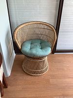 Front view of vintage rattan peacock chair with attached seat cushion
