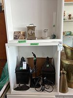 Top shelf with brass carriage clock, postcard and small vase