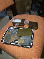 Wide view of brass boxes and tray containing metal stamping dies