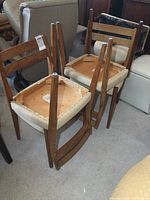 All four chairs stacked upside down showing underside construction and foot caps