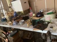 Full view of the folding table loaded with various items and its surface showing wear.