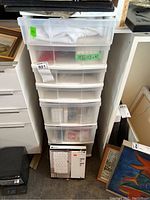 Tall seven-drawer clear plastic storage unit packed with fabric and crafting supplies