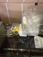 Photo showing various included accessories such as thread spools, bobbins, pins, and part of foot pedal cable on the table.