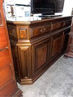 Side view of wood server cabinet showing decorative panels, drawers and doors