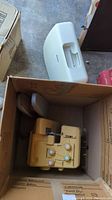 Kenmore sewing machine and Bernette serger in storage box with case lid visible on floor.