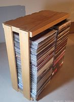 Side view of wooden storage crate filled with stacked music CDs.