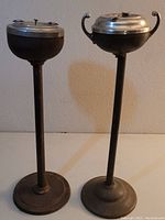 Front view of two vintage standing ashtrays showing their full height and bases