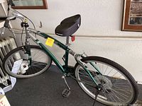 Side view showing entire Avalon Nexus bicycle with green and silver frame, front suspension, and saddle.