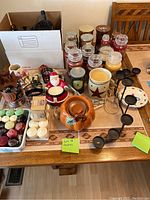 Overview of various candles, wax melts, and candle holders on a wooden table.