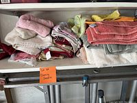 Stack of assorted cleaning towels in various colors on a shelf