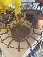 Circular metal train-themed decorative piece with locomotive and carriage on a round base