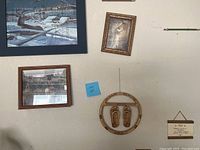 Photo showing three wall art pieces including the deer painting, scenic landscape, and circular wooden decorative piece