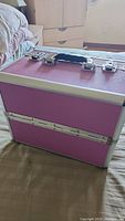 Closed pink makeup case showing exterior and handle