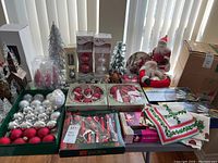 Overview photo of entire lot showing all Christmas decorations including ornaments, lights, figurines, and linens.