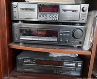 Front view of Sony cassette deck with dual tape compartments, receiver with control knobs, and 5-disc CD player.