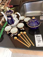 Photo of Weimar Kobalt coffee set showing coffee pot, six espresso cups with saucers, sugar bowl with lid, and four gold-toned spoons arranged on countertop.