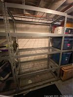 Silver 5-shelf heavy duty industrial welded steel garage storage rack with wire grid shelves in a basement setting.