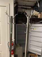 Photo showing the top and mid section hooks of the grey metal coat racks, confirming multiple prongs for hanging clothes.