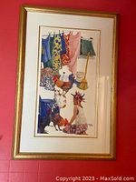 Full photo of the framed colorful print with a woman, roosters, and hanging clothes