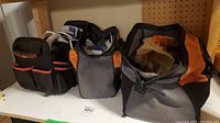 Photo showing three tool bags containing electrical repair tools and supplies on a shelf.