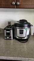 Photo showing the Instant Pot pressure cooker and Oster toaster side by side on a countertop.