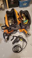 Overview of three corded drills in orange and black tool bags