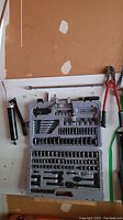 Gray plastic carrying case open showing Stanley black chrome socket set with various sockets and bits.
