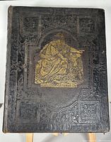 Front cover of Bible showing embossed leather with gilt image of Moses viewing the promised land.