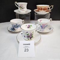 Group photo of 5 bone china tea cups with saucers, showing variety of floral designs and patterns.