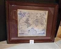 Photo of the framed world map showing entire frame and matting with map visible beneath glass.