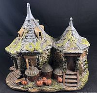 Porcelain Hagrid's Hut figurine showing detailed exterior with pumpkins, wood steps and mossy roof under normal light.