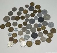 Coins assorted on white background, showing a variety of metal types and sizes in a random arrangement