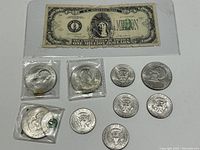 Overview of the coins and one million dollar bill laid flat showing all items in the lot