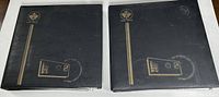 Two black albums with gold Canadian postal emblem and text on covers