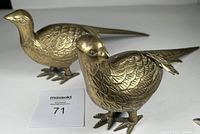 Pair of vintage brass pheasant figurines shown from side angle highlighting detailed etched feathers and feet.
