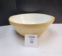 Front view of the bowl showing white interior and beige exterior with textured rim.