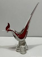 Side view of the Murano glass rooster showing long tail and ruby red with clear glass body