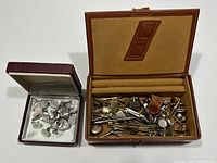 Two boxes with vintage men's estate jewelry, one larger with assorted tie clips and cufflinks, one smaller with mother-of-pearl cufflinks